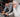 Young man helping elderly man with headphones to use a smartphone at home