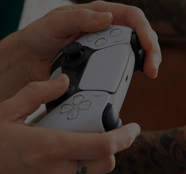 A man's hand holding a game console controller