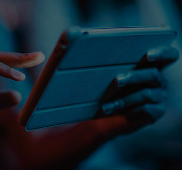 Person holding a tablet with a dark blue filter