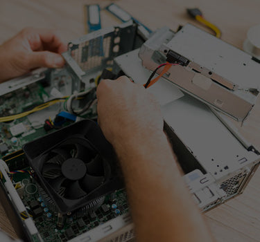 Person working on a computer motherboard with tools in the background