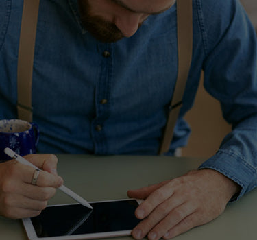 Man using a stylus on a tablet with a blurred background