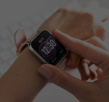 A woman's hand wearing a pink Apple Watch.