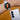 Smartwatch on a wrist with a smartphone next to it on an orange background