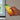 Hand holding a smartphone with a colorful display in front of a window