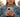 Woman in a coat holding an iPhone outdoors with a worried expression