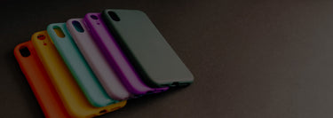 Five colorful phone cases on a dark surface