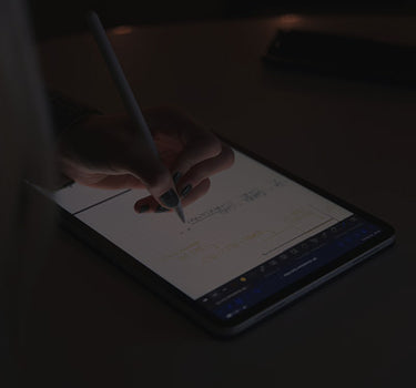 Person using a stylus on a tablet with a dark background