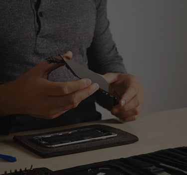 Person repairing a hair dryer with tools on a table