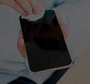 Person cleaning a smartphone screen with a cloth