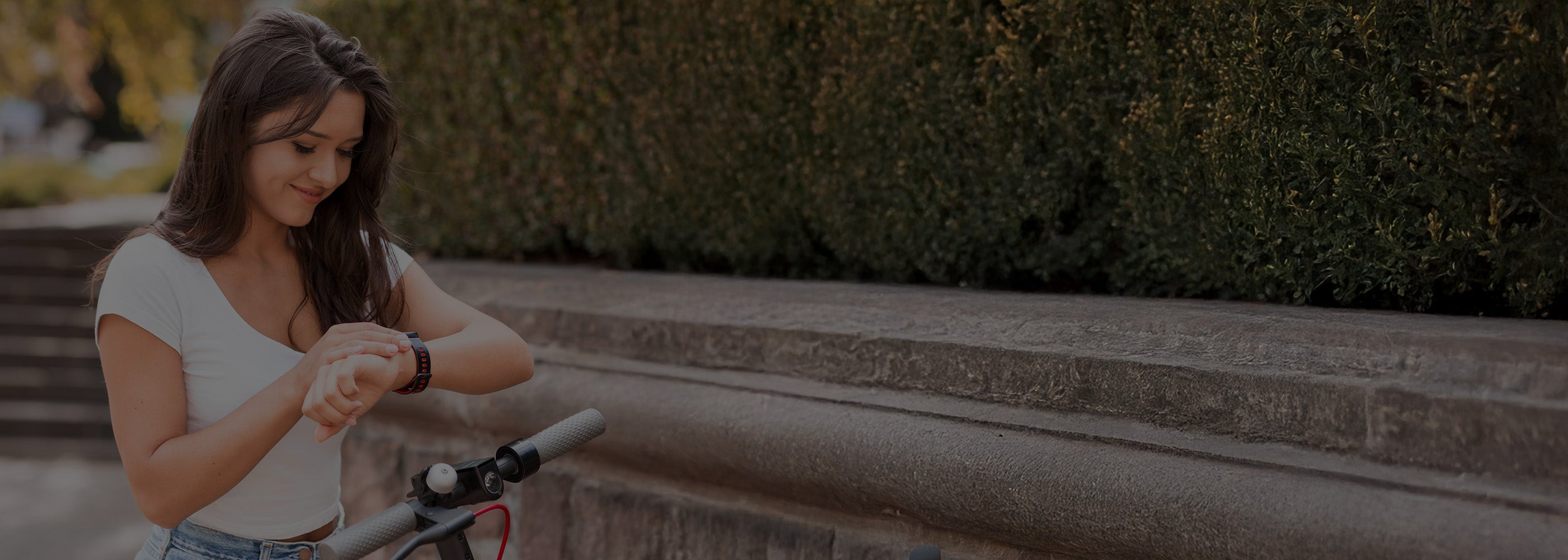 Woman adjusting her smartwatch outdoors with blurred background