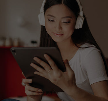 A woman wearing headphones and using a tablet