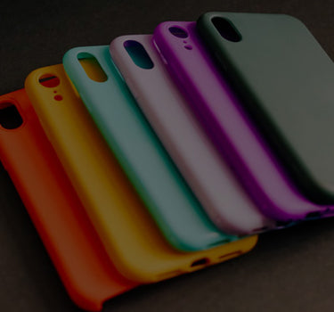 Set of colorful phone cases arranged in a row on a dark surface