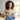 Smiling woman with curly hair using a tablet indoors.