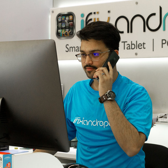 iFixandRepair technician assisting customer over the phone in front of computer