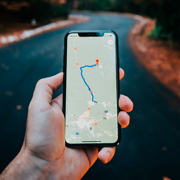 Hand holding smartphone showing navigation route on screen