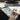 Person using a stylus to draw on a digital tablet with a computer in the background